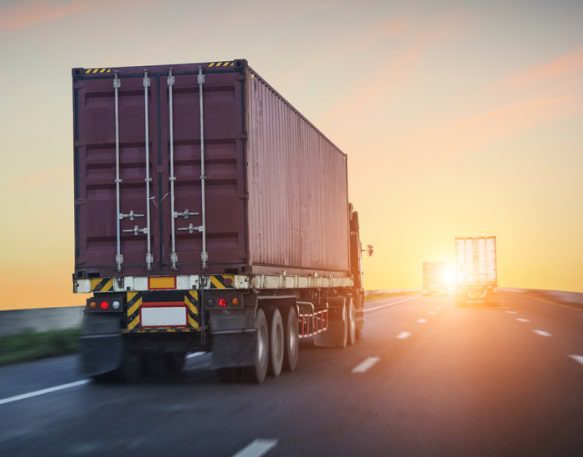 A truck drives into the sunset.