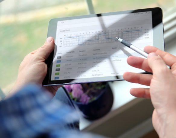 Man logging trucking data on a tablet.