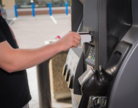 A truck driver uses their fleet fuel card at the gas station.