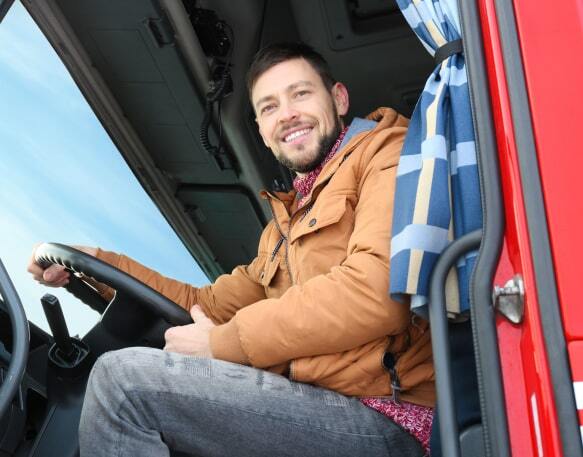 Truck driver sitting in the cabin of his truck.