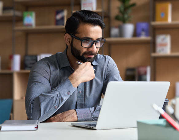 Shipper sitting at desk working on a laptop.