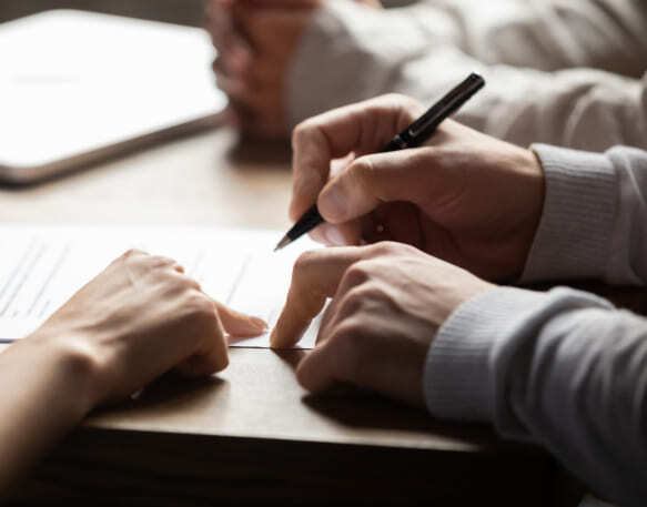 A truck driver signs a lease purchase agreement.