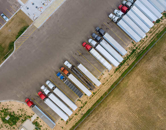 Aerial top view truck stop parking at the rest area on the highway trucks stand in a row.